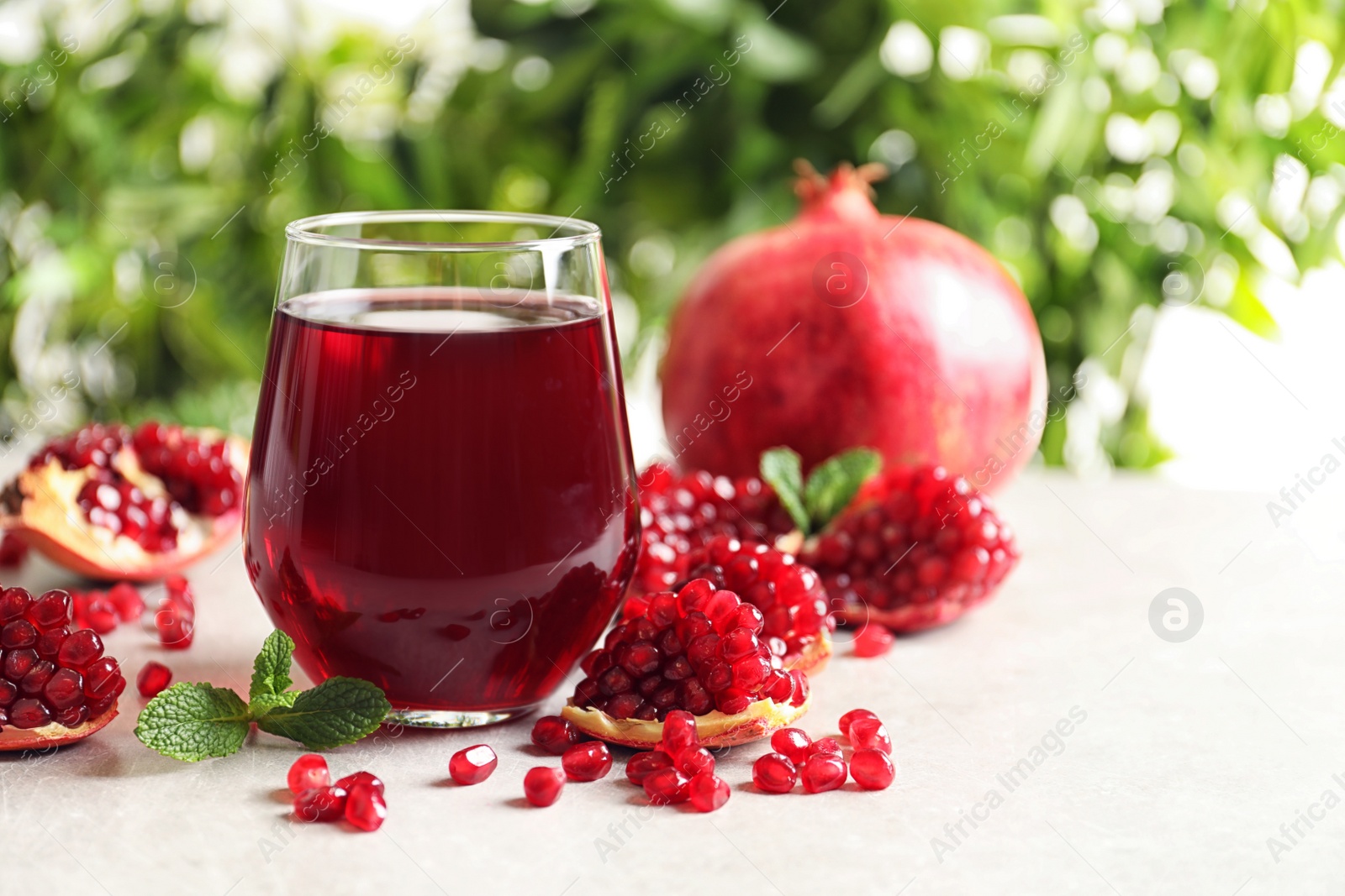 Photo of Composition with glass of fresh pomegranate juice on table. Space for text