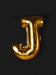 Photo of Golden letter J balloon on black background