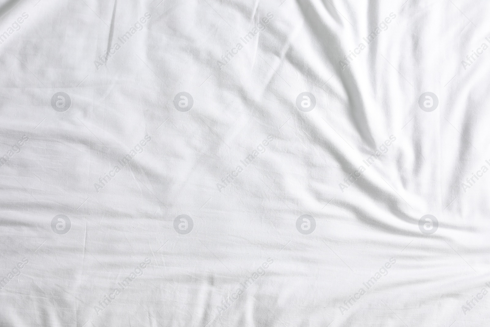 Photo of Crumpled white fabric as background, top view