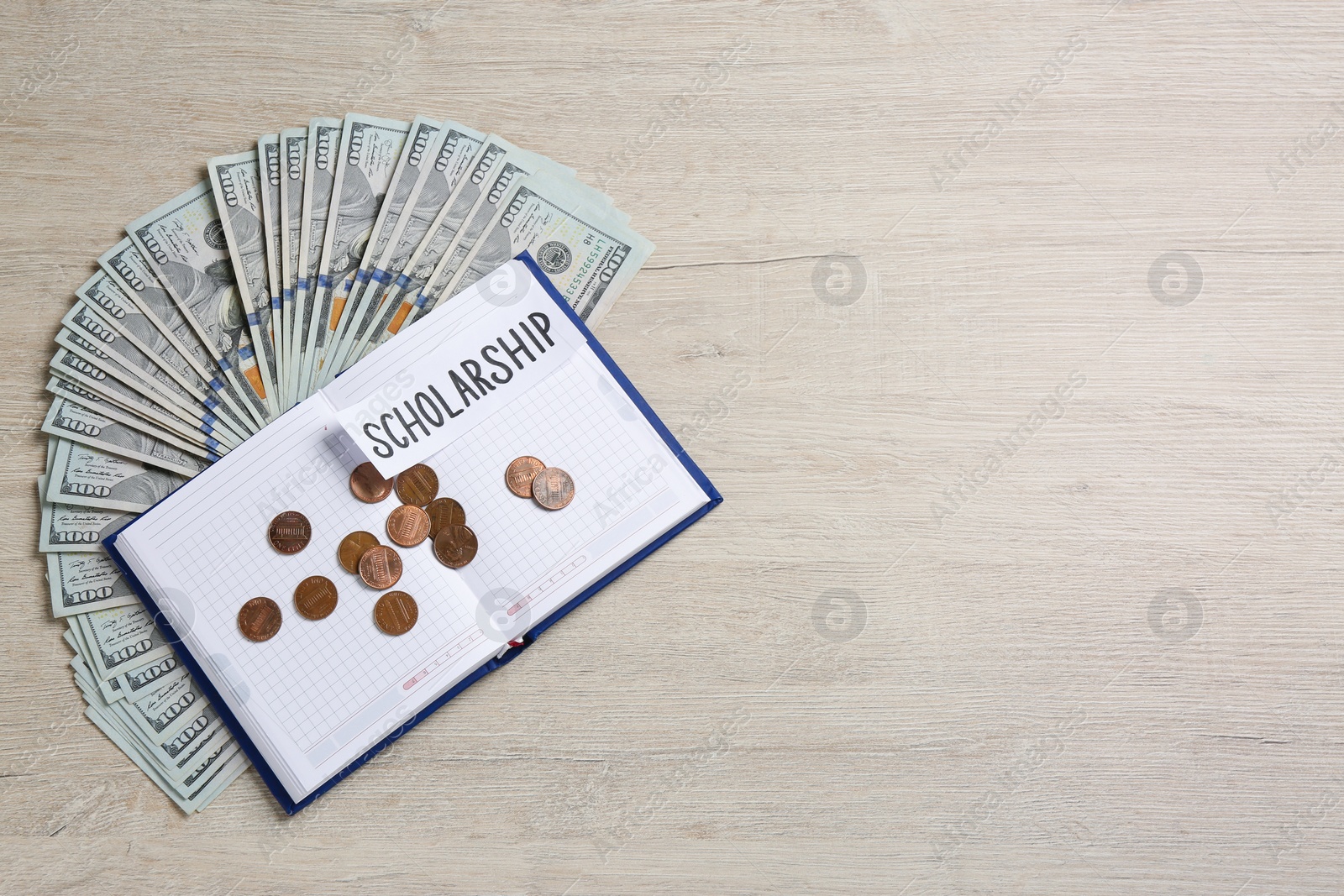Photo of Paper with word Scholarship, notebook, banknotes and coins on wooden table, flat lay. Space for text