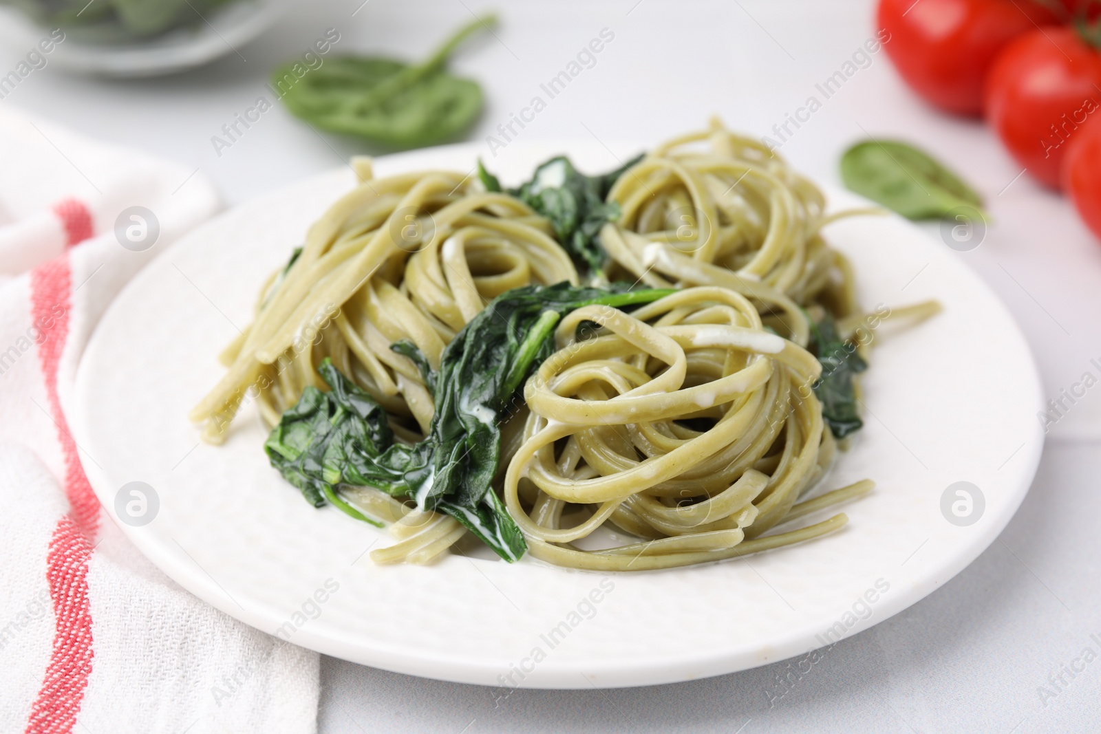 Photo of Tasty pasta with spinach and sauce on white table, closeup