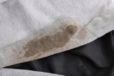 Photo of Grey jacket with stain of coffee, closeup