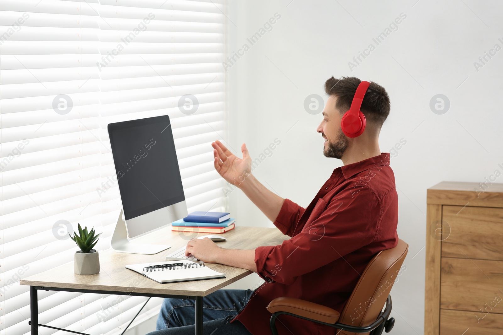 Photo of Man in headphones studying on computer at home. Online translation course