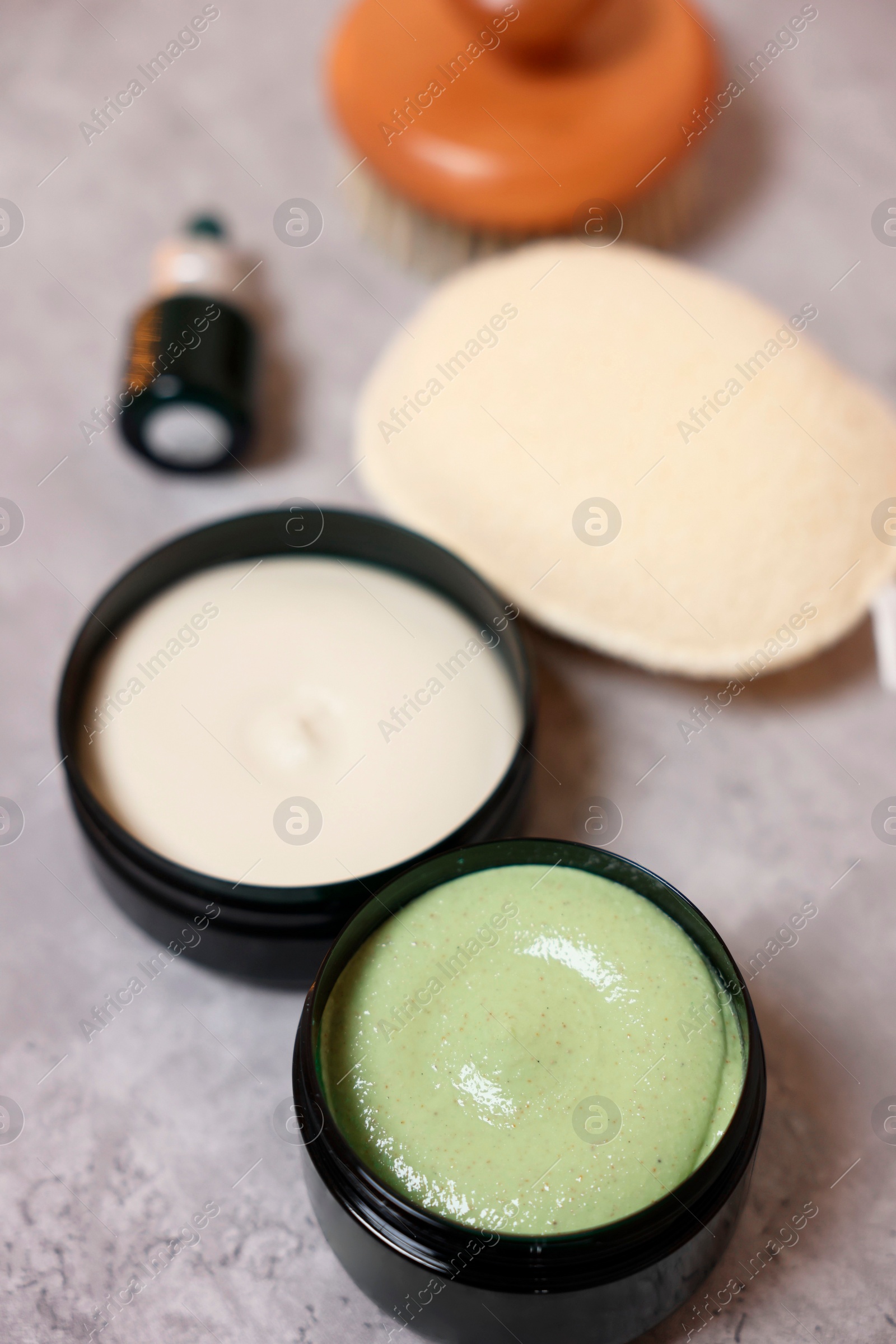 Photo of Natural body scrub, cream and sponge on grey table