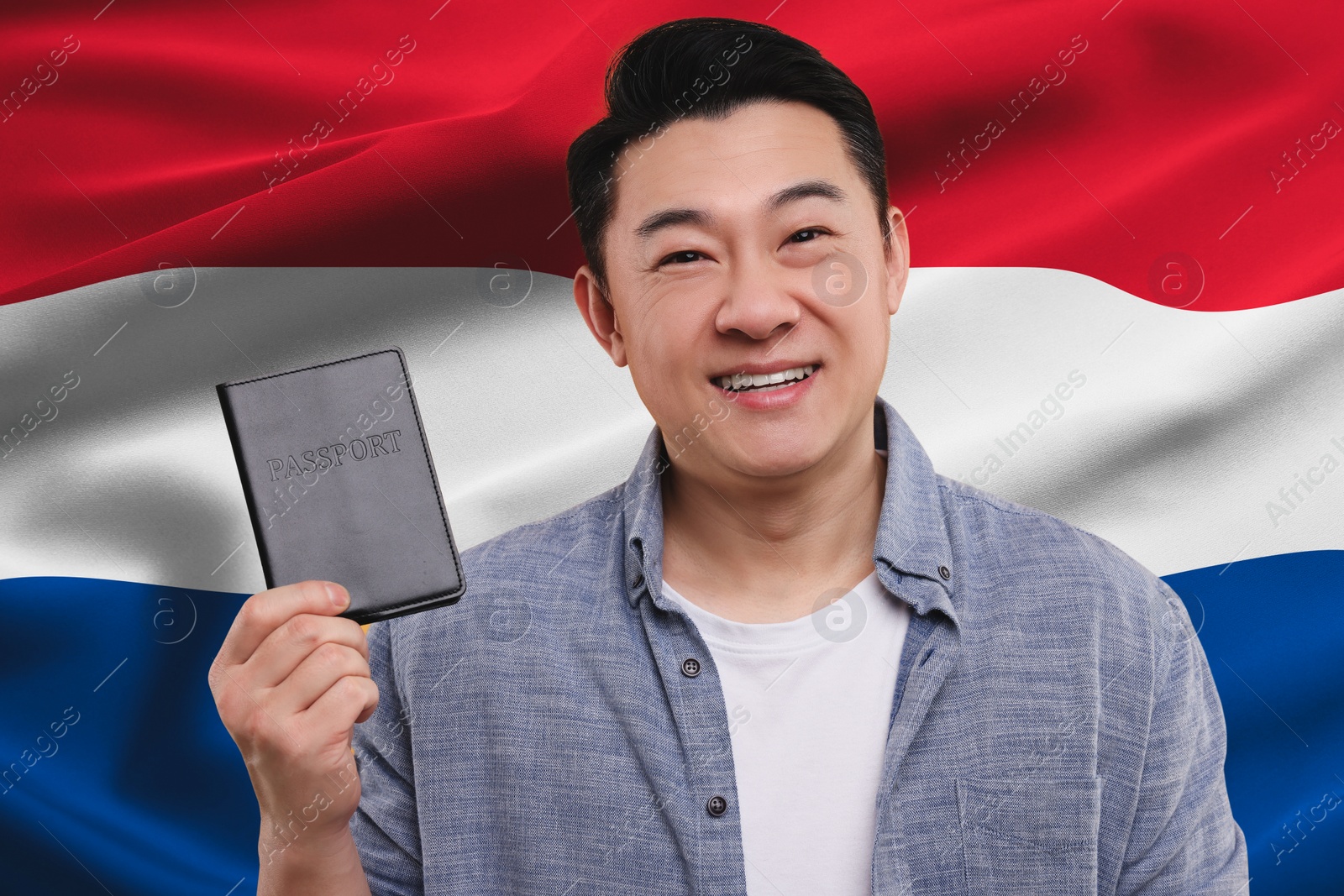 Image of Immigration. Happy man with passport against national flag of Netherlands