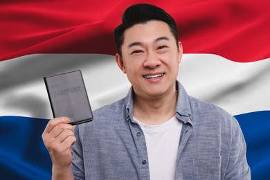 Immigration. Happy man with passport against national flag of Netherlands