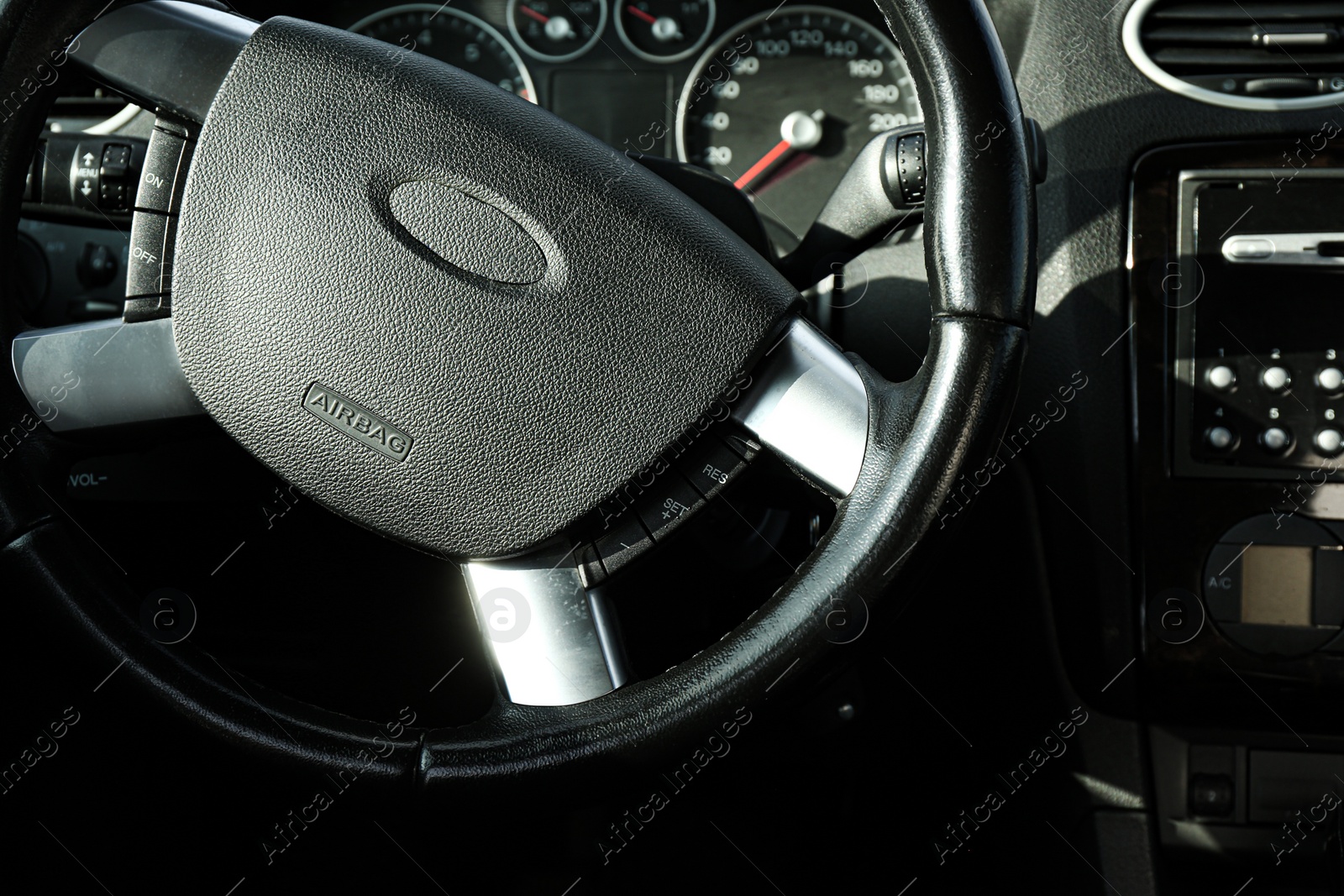 Photo of Black steering wheel and dashboard in car