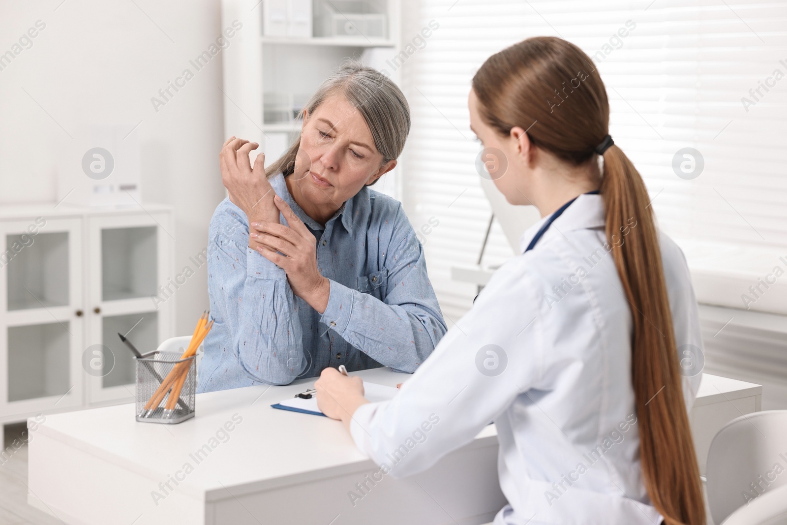 Photo of Arthritis symptoms. Doctor examining patient's wrist in hospital