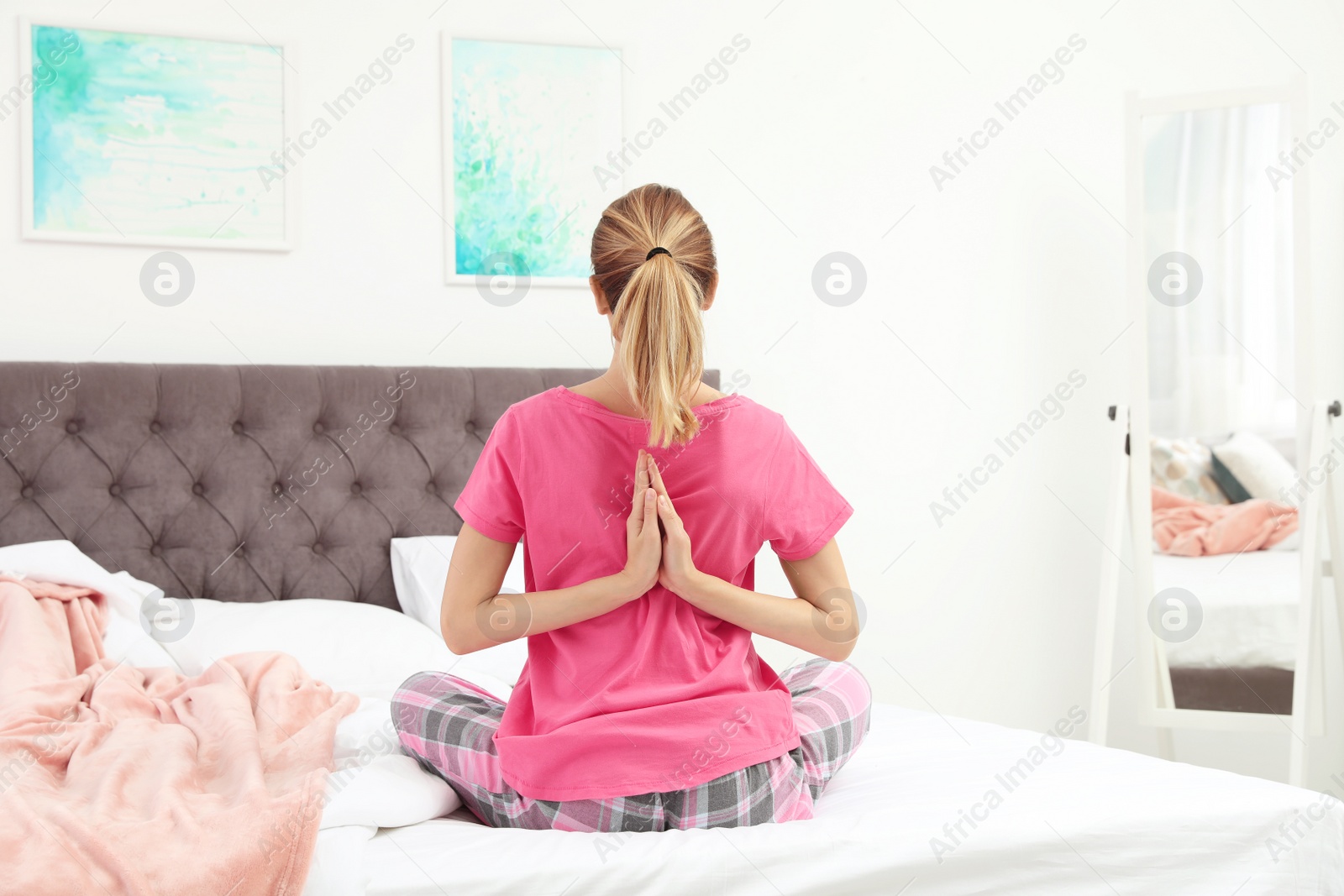 Photo of Young beautiful woman doing exercise on bed at home. Morning fitness