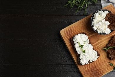 Photo of Bread with cottage cheese and microgreens on black wooden table, flat lay. Space for text