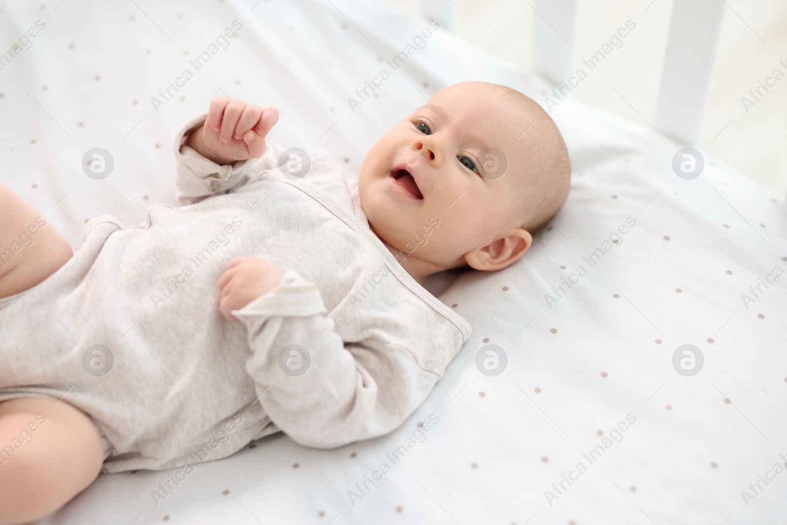 Photo of Cute little baby lying in crib at home