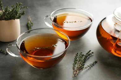 Aromatic herbal tea with thyme on grey table