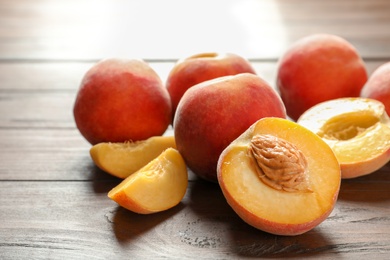 Photo of Fresh sweet peaches on wooden table, closeup