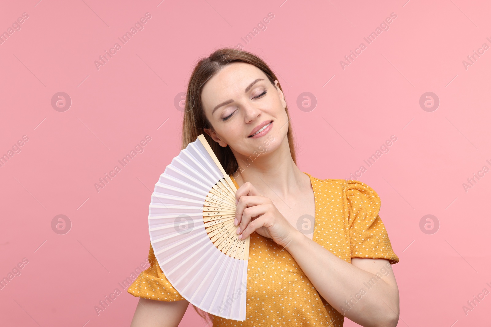 Photo of Beautiful woman with hand fan on pink background