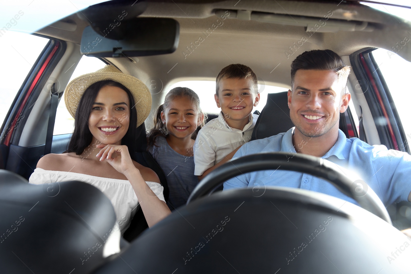 Photo of Happy family in car on road trip, view from outside