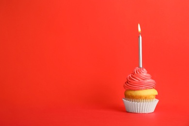 Photo of Birthday cupcake with candle on red background, space for text