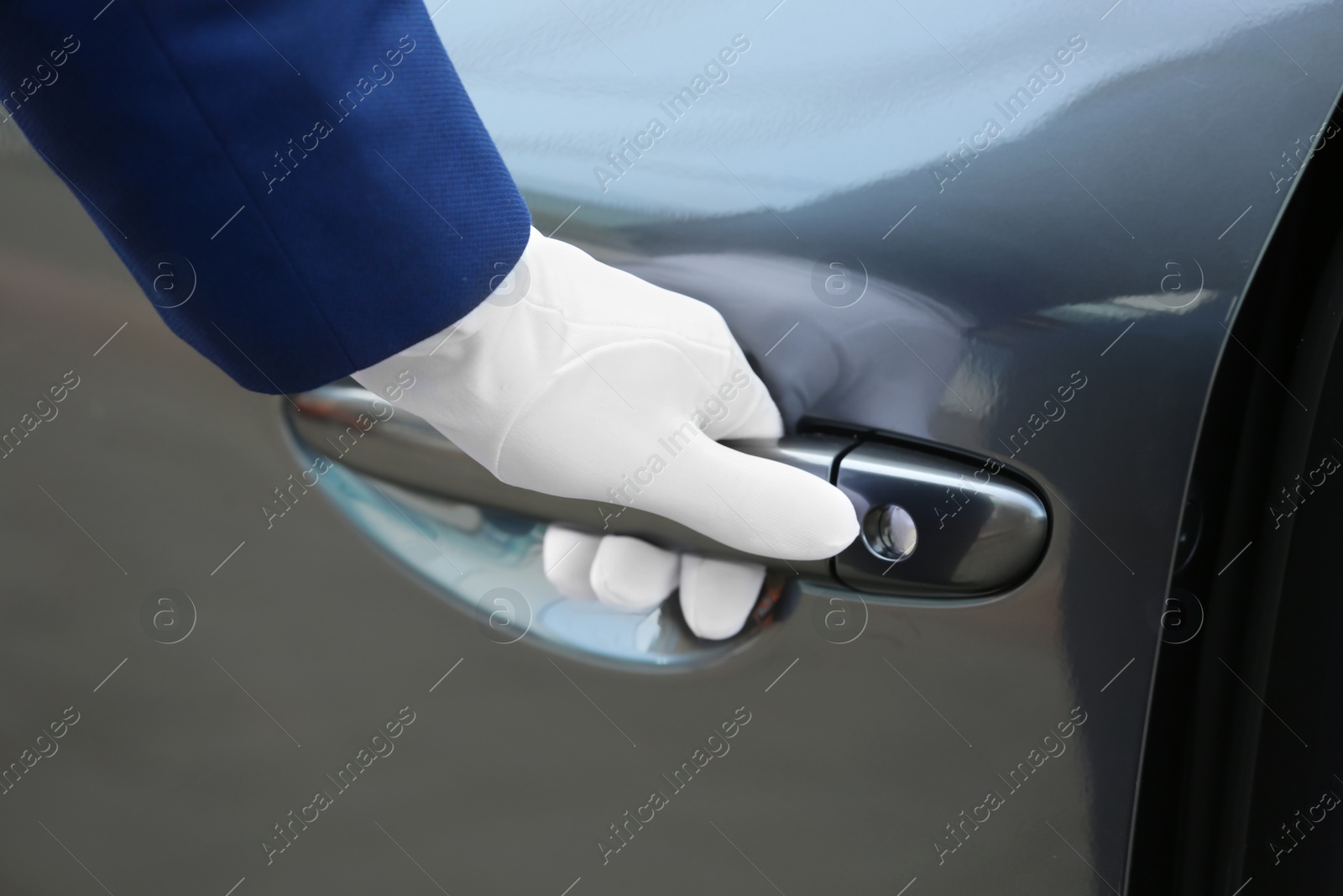 Photo of Closeup view of chauffeur opening car door