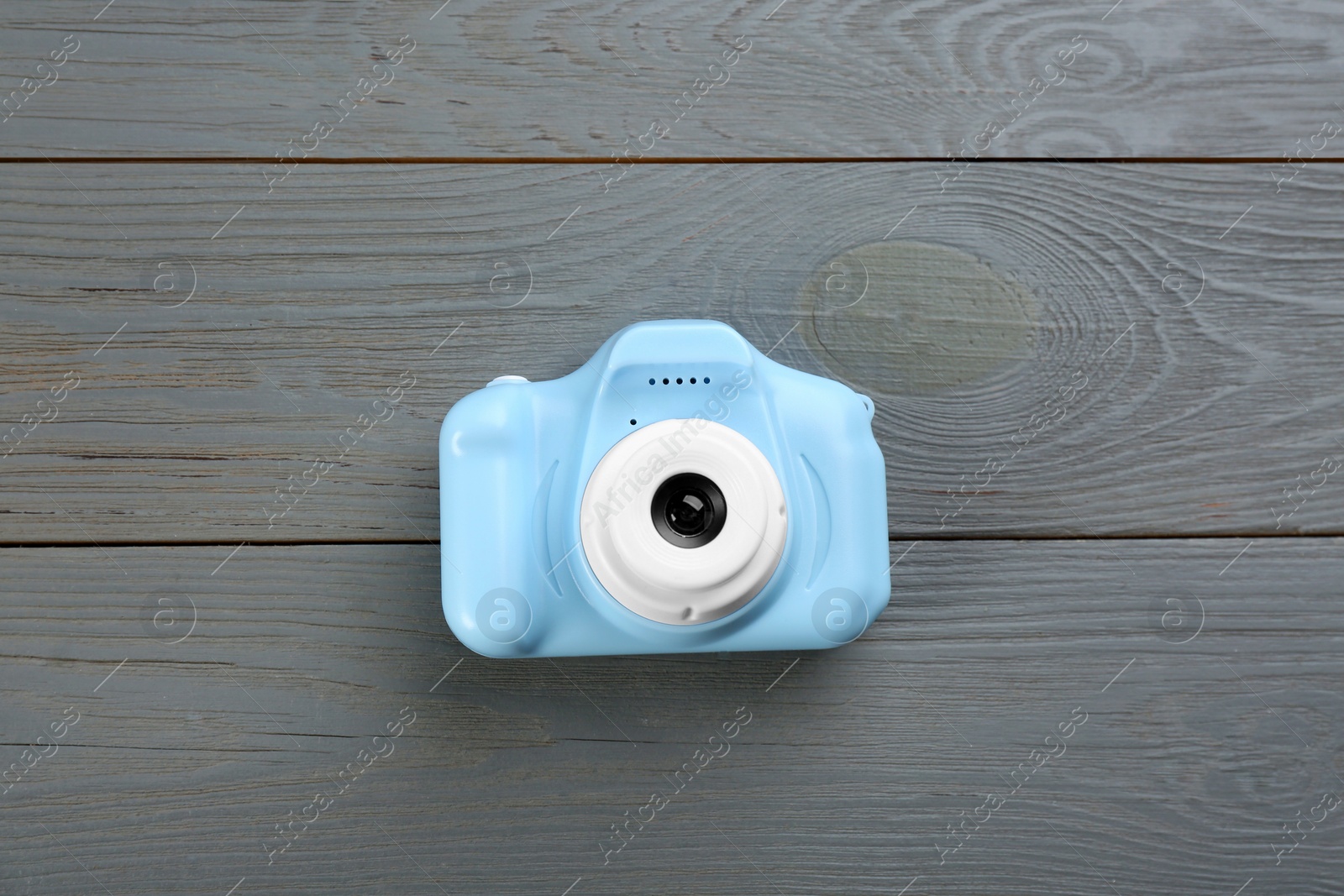 Photo of Light blue toy camera on grey wooden background, top view