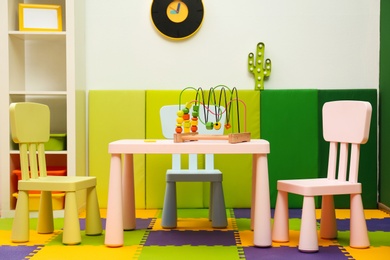 Stylish playroom interior with table and chairs