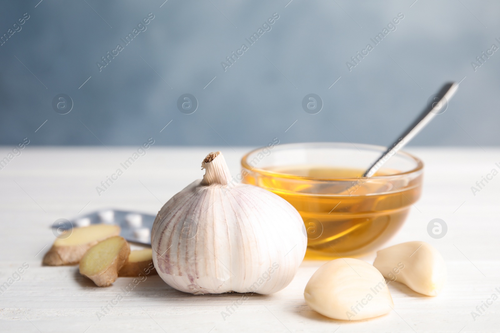 Photo of Composition with garlic and other cold remedies on white wooden table