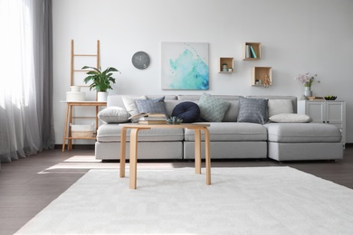 Photo of Elegant living room with comfortable sofa and wooden table. Interior design