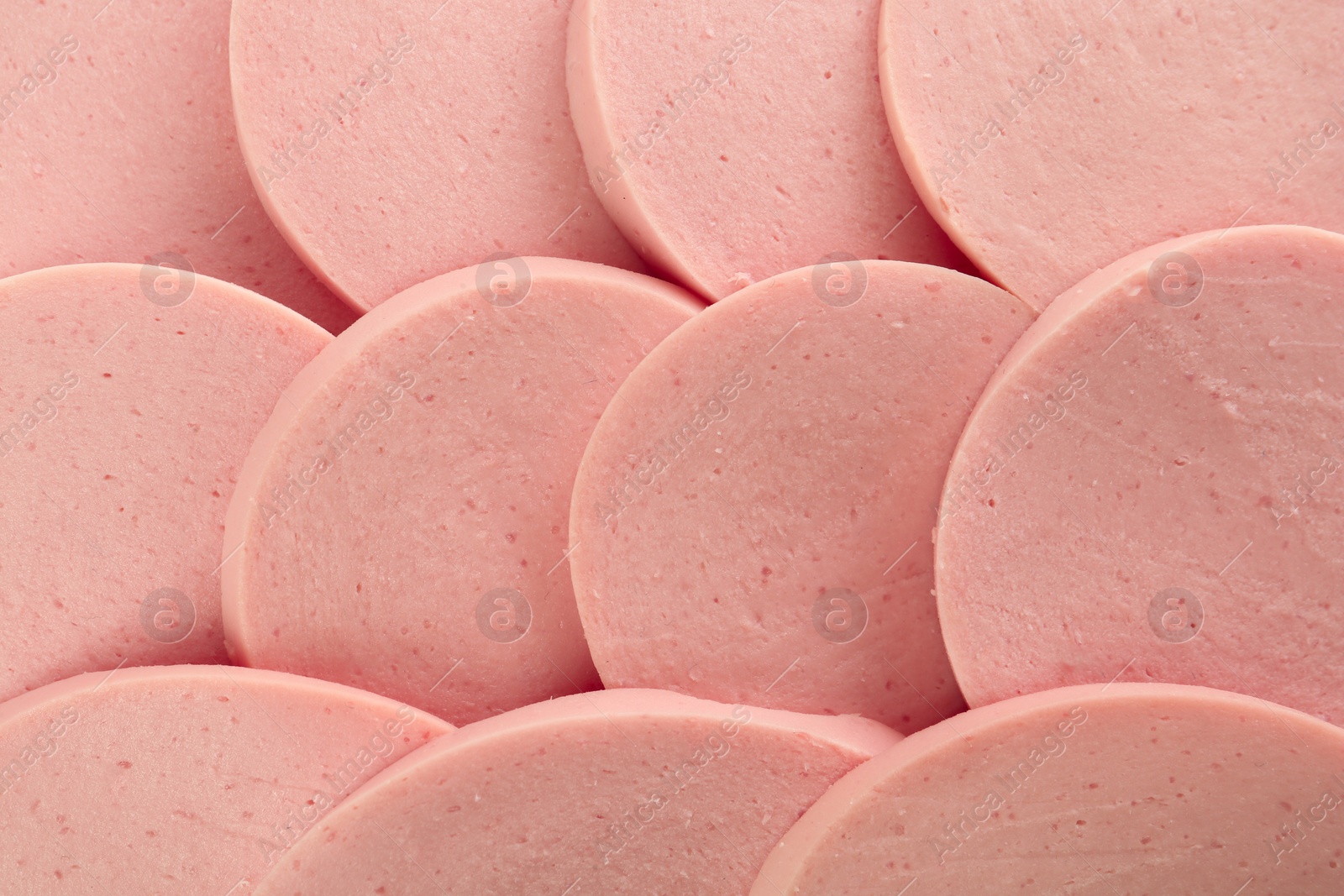 Photo of Slices of tasty boiled sausage as background, top view