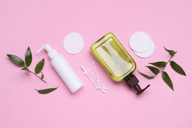 Photo of Different cleansers, leaves, cotton buds and pads on pink background, flat lay with space for text. Cosmetic product