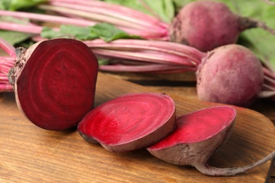 Cut ripe beet on wooden board, closeup