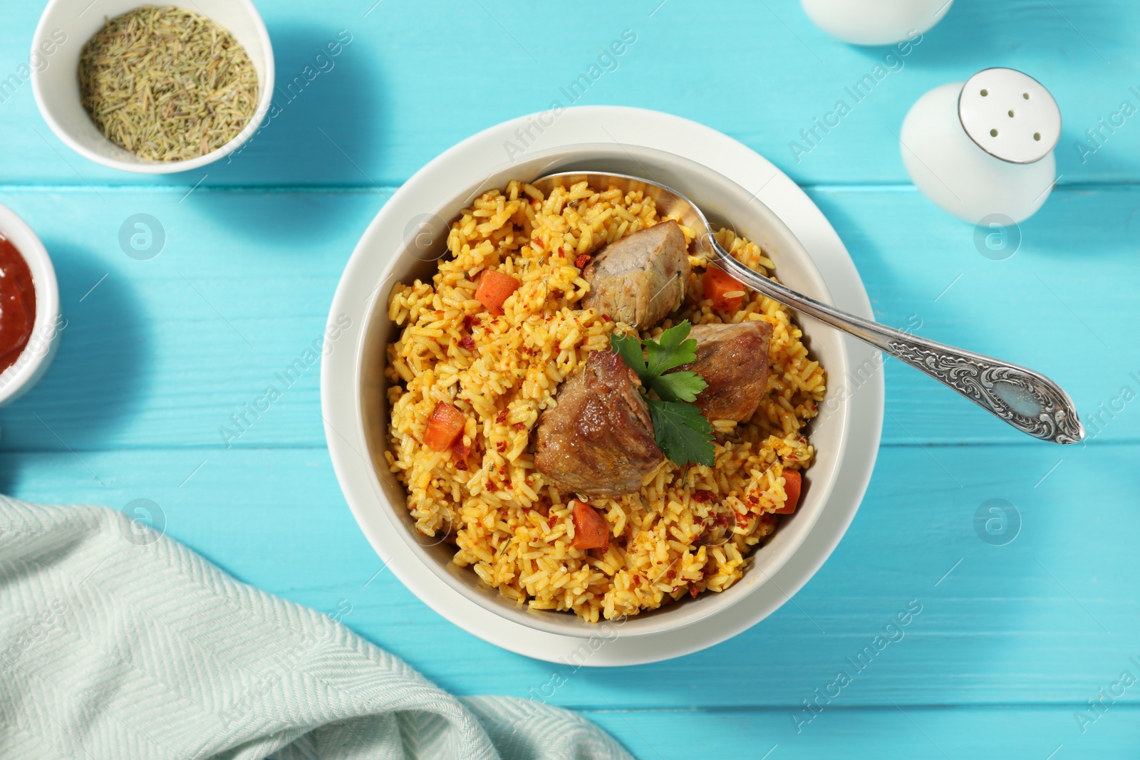 Photo of Delicious rice pilaf served on wooden table, flat lay