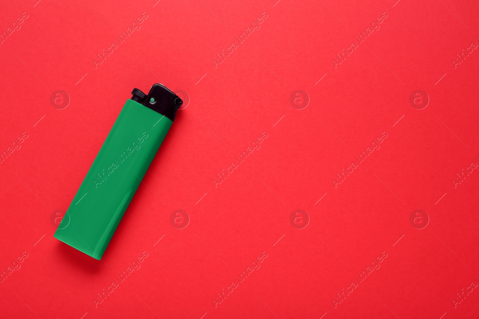 Photo of Stylish small pocket lighter on red background, top view. Space for text