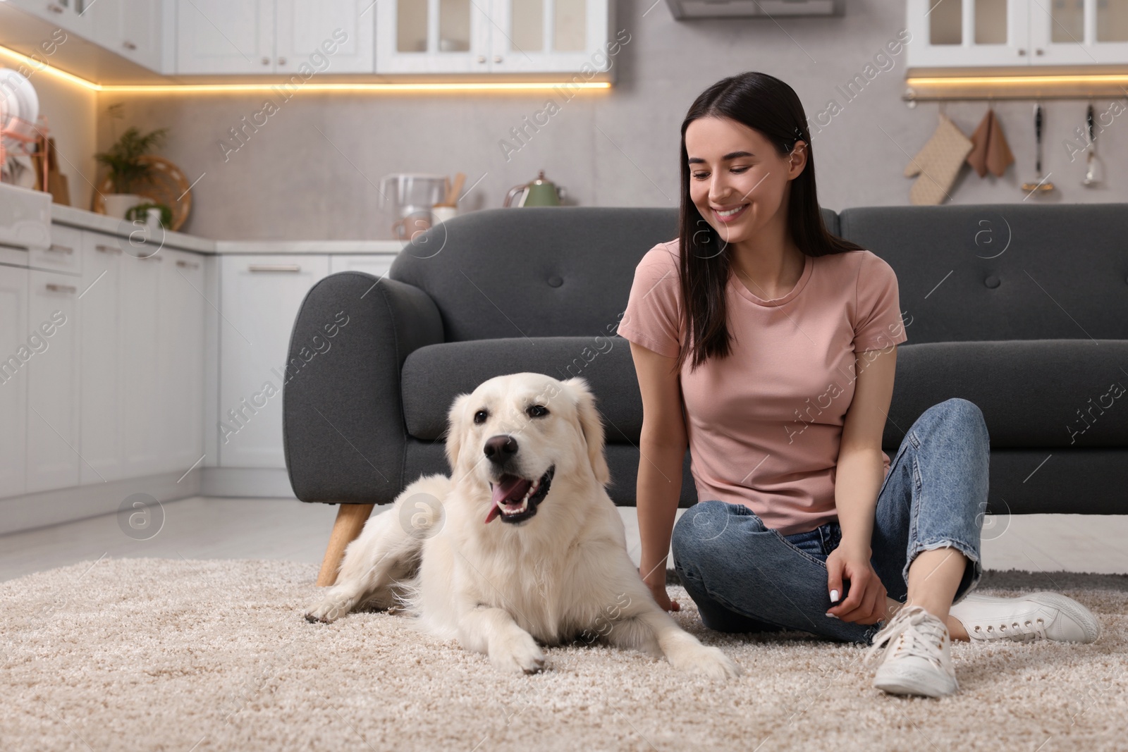 Photo of Happy woman with cute Labrador Retriever dog on floor at home. Adorable pet