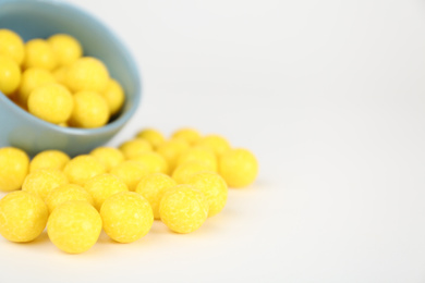 Tasty small lemon drops on white background