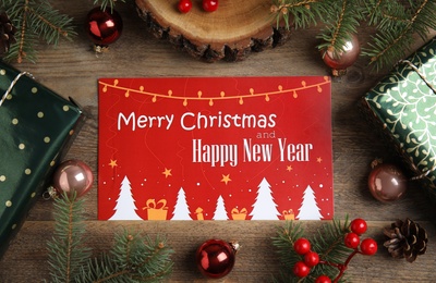 Flat lay composition with greeting card and Christmas decor on wooden background