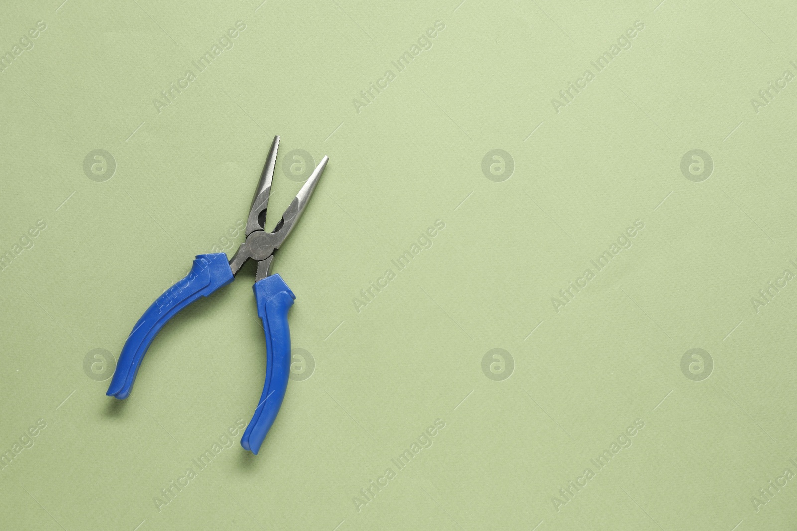 Photo of Needle nose pliers on olive background, top view. Space for text