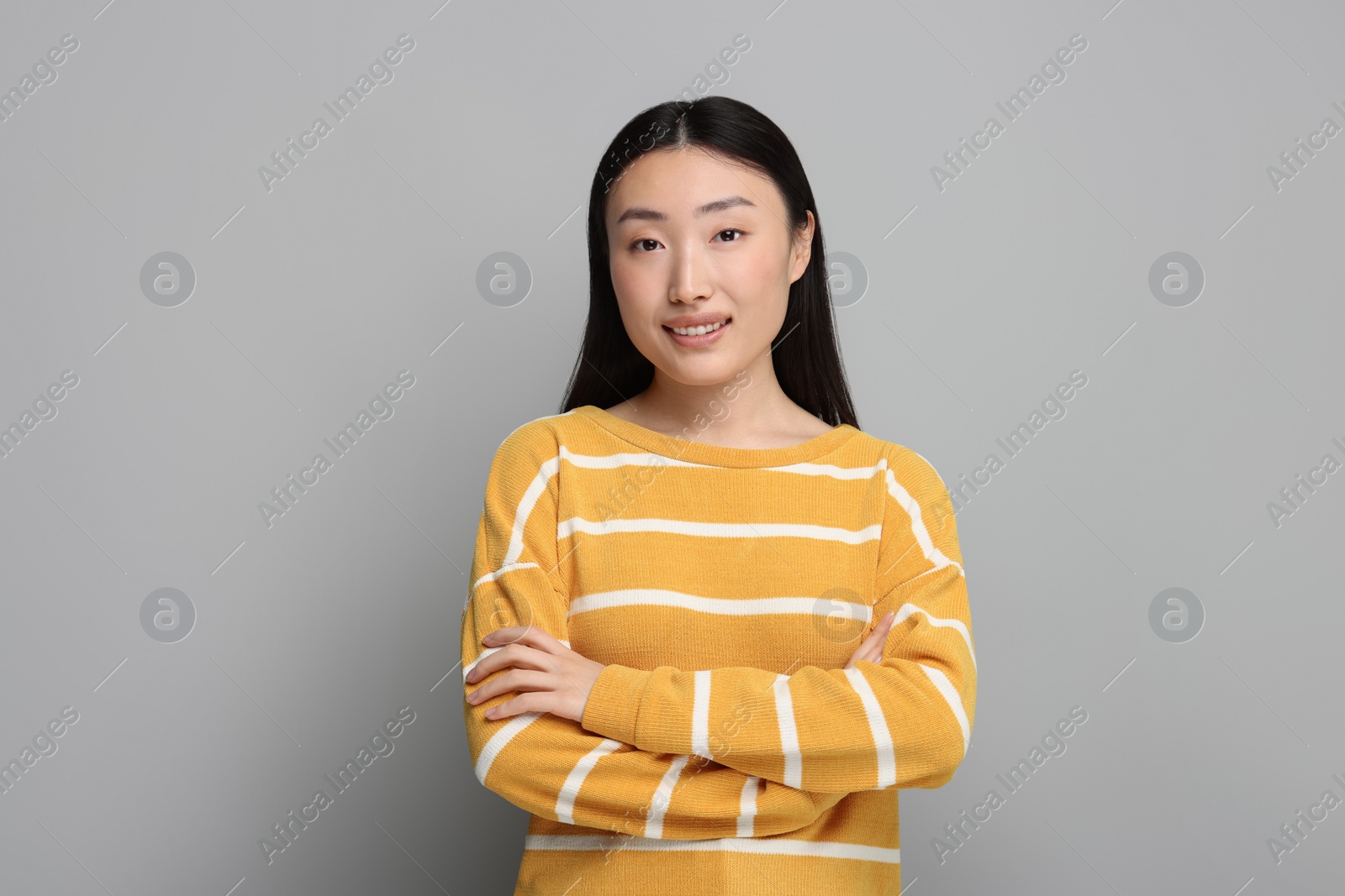 Photo of Portrait of smiling woman on grey background