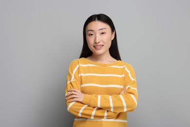 Portrait of smiling woman on grey background