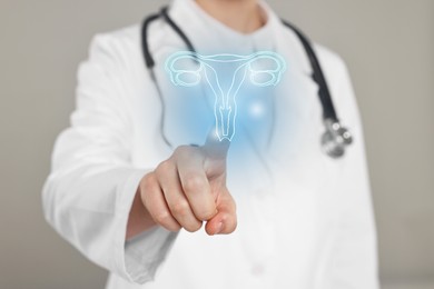 Doctor and illustration of female reproductive system on grey background, closeup