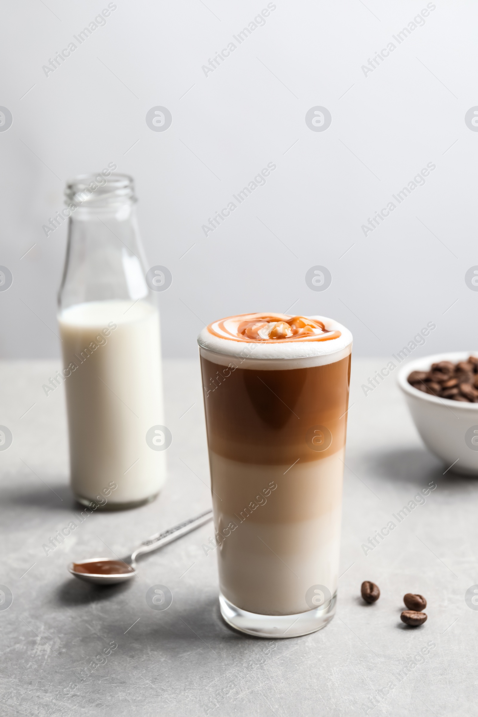 Photo of Glass with delicious caramel latte on table