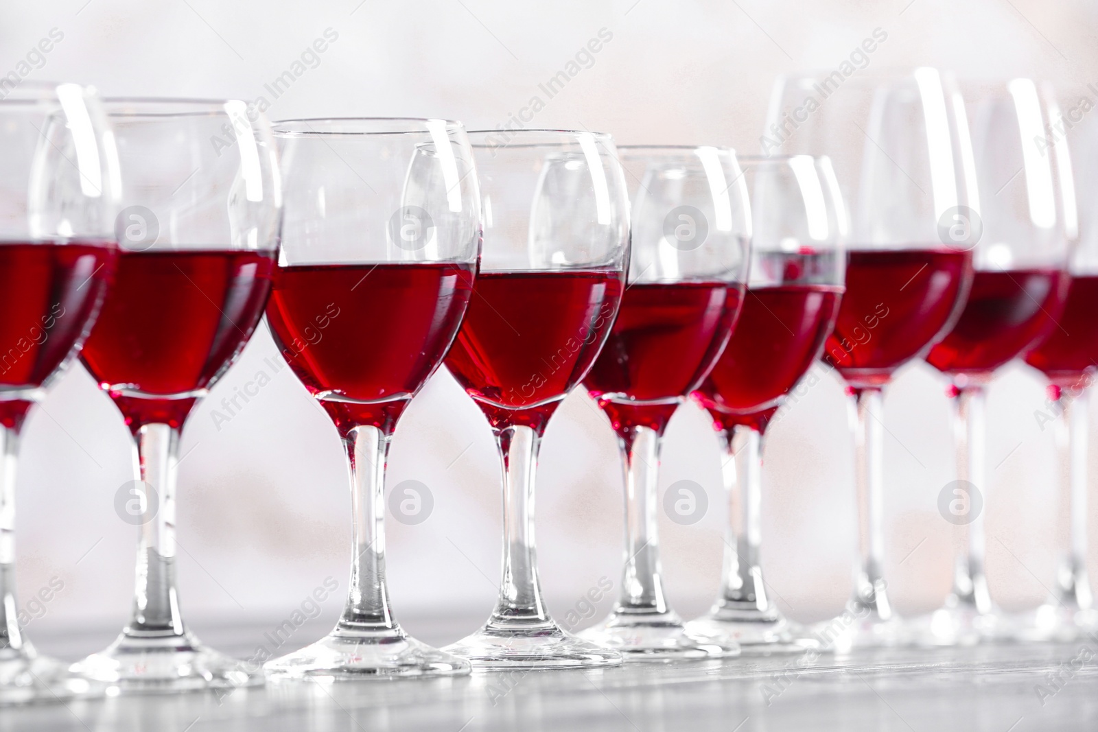 Photo of Glasses with delicious red wine on table