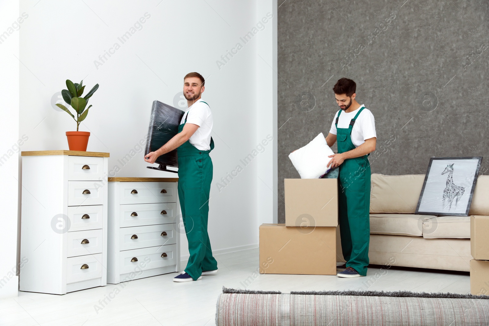 Photo of Young men in uniform working indoors. Moving service