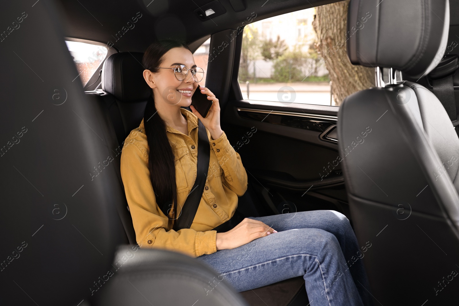 Photo of Woman with seatbelt talking on phone inside car