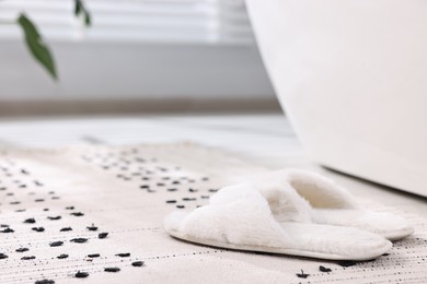 Photo of White soft slippers on carpet at home. Space for text