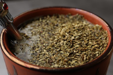 Photo of Guampa with bombilla and mate tea on table, closeup