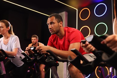 Group of people training on exercise bikes in fitness club