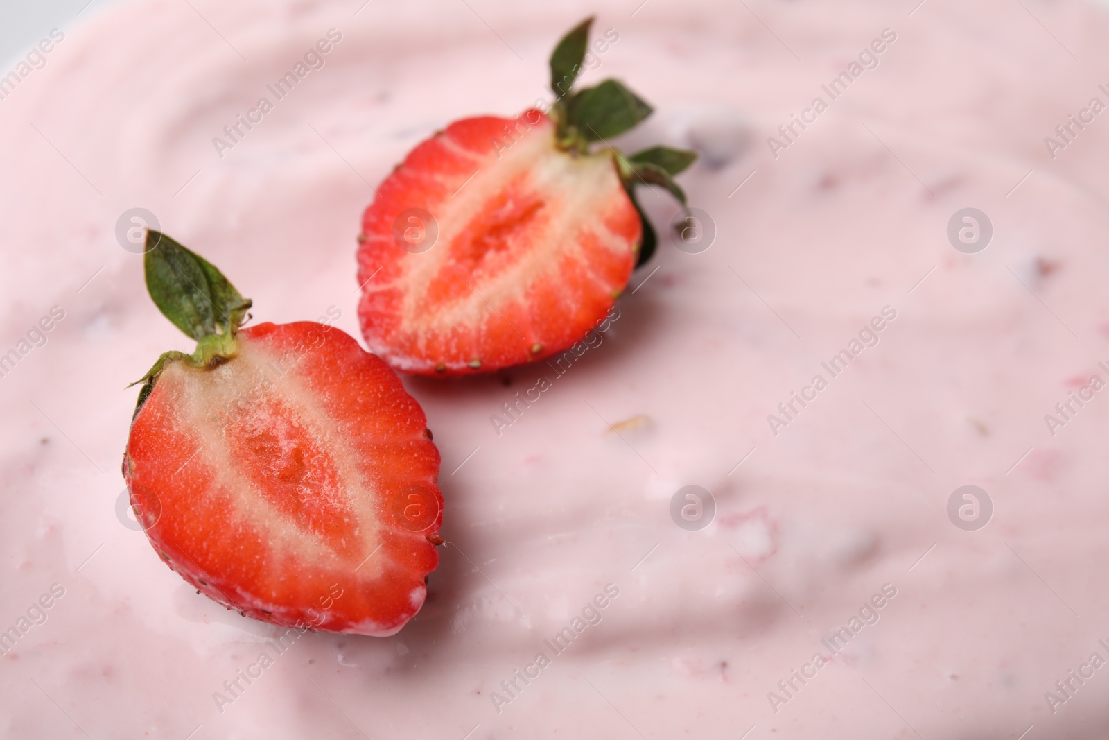 Photo of Tasty yogurt and strawberries as background, closeup. Space for text
