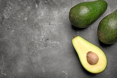 Delicious ripe avocados on grey table, flat lay. Space for text