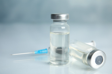 Vials and syringe on light table. Vaccination and immunization