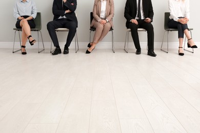 Photo of People waiting for job interview in office hall, closeup