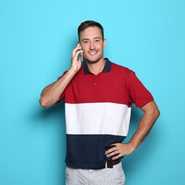 Photo of Young man talking on phone against color background