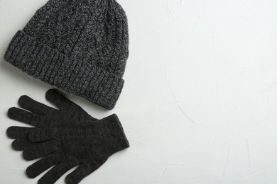 Stylish gloves and hat on white background, flat lay. Space for text